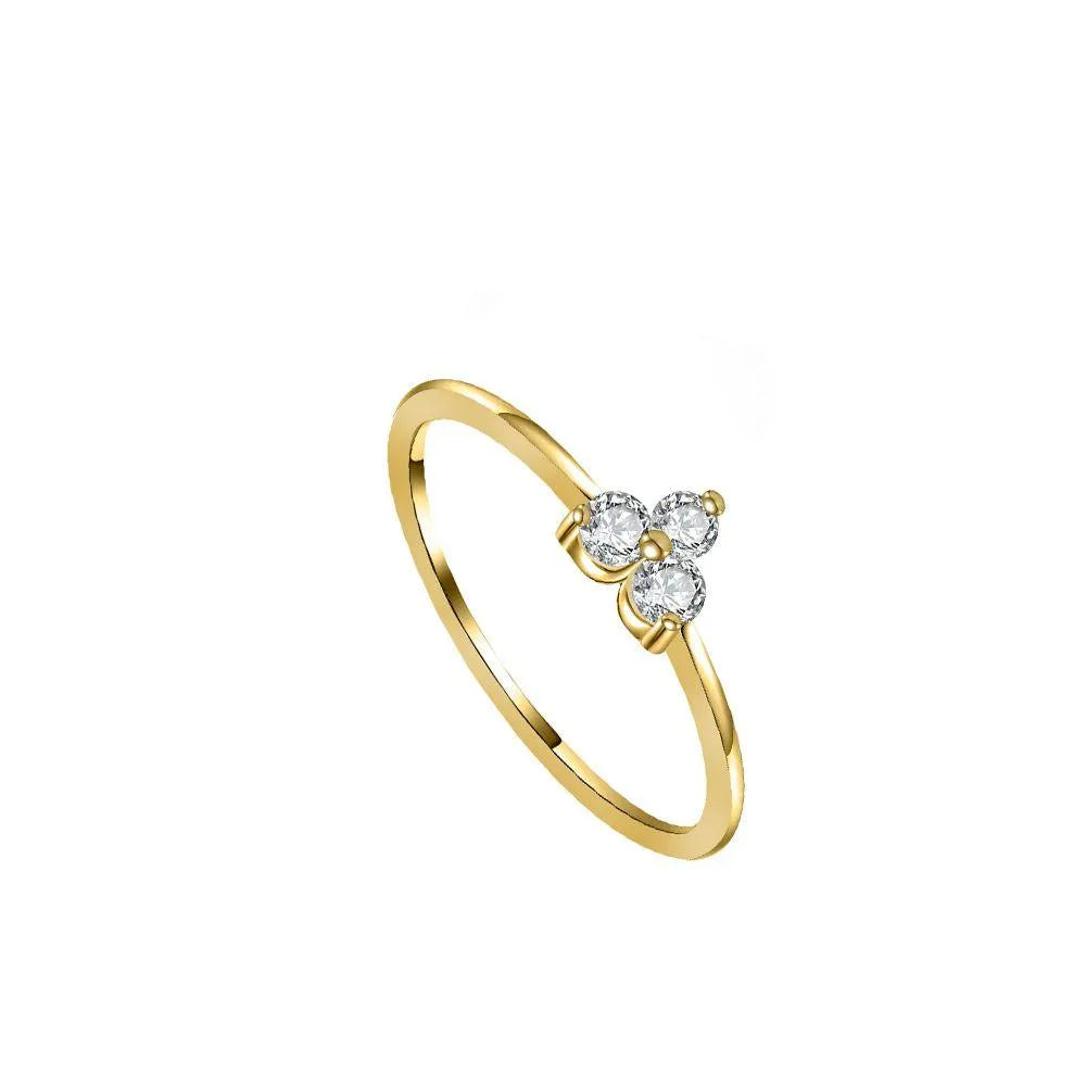 Anillo de tres circonitas de colores visto de cerca, diseño fino y luminoso