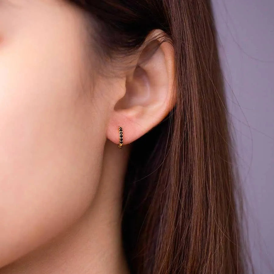 Detalle del aro de 11 mm con circonitas negras, pendiente fino con brillo oscuro
