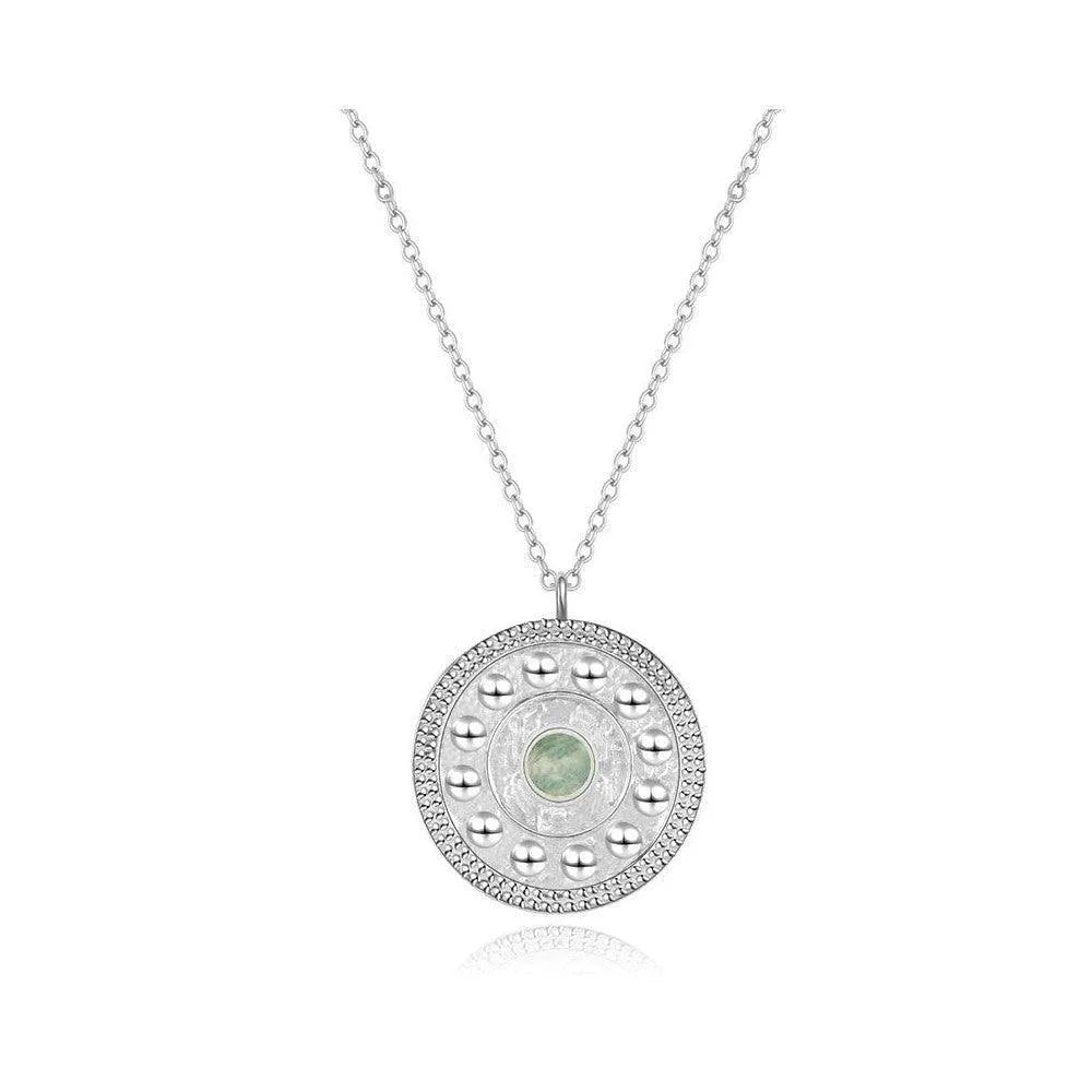 Detalle del collar moneda con piedra, pieza fina con colgante redondo y piedra natural