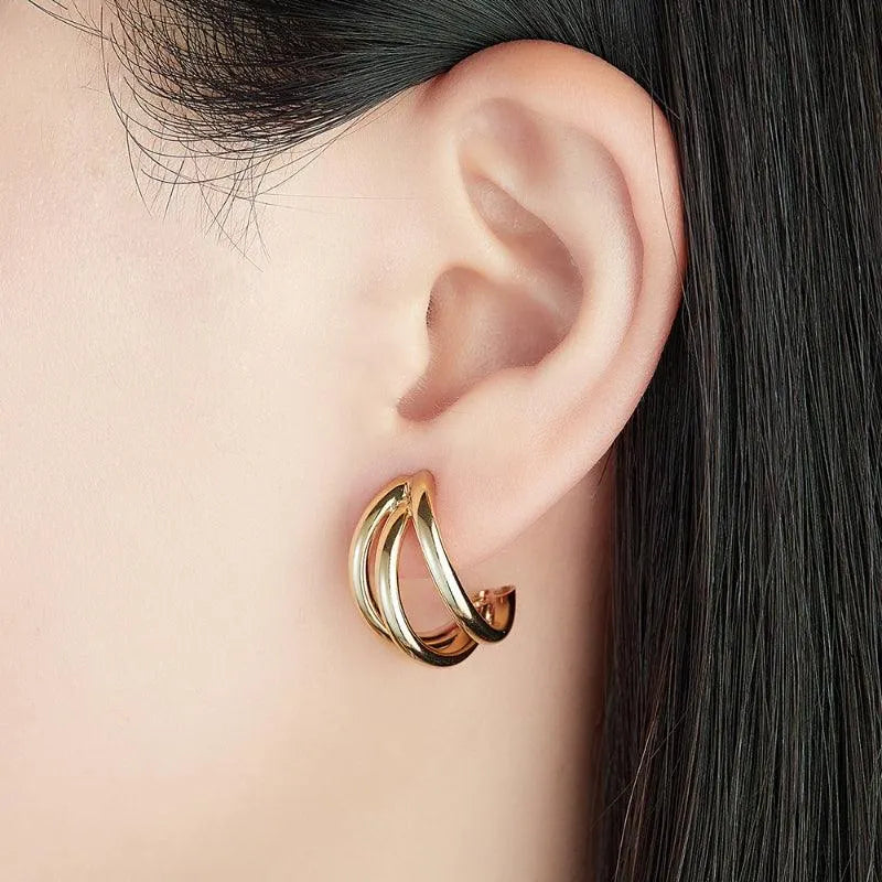 Detalle de pendientes aro triple en plata y oro, pieza moderna y luminosa